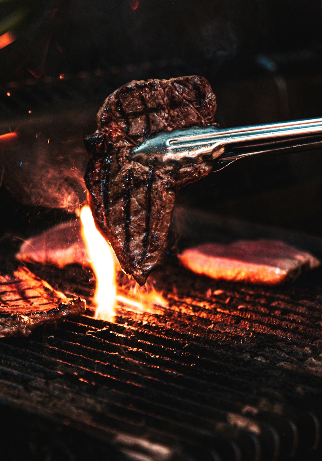 Fleisch über offener Flamme am Grill