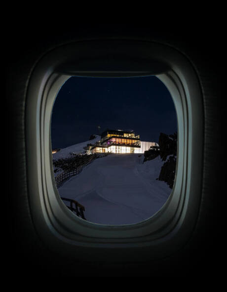 Blick durch ein Flugzeugfenster auf das ice Q bei Nacht